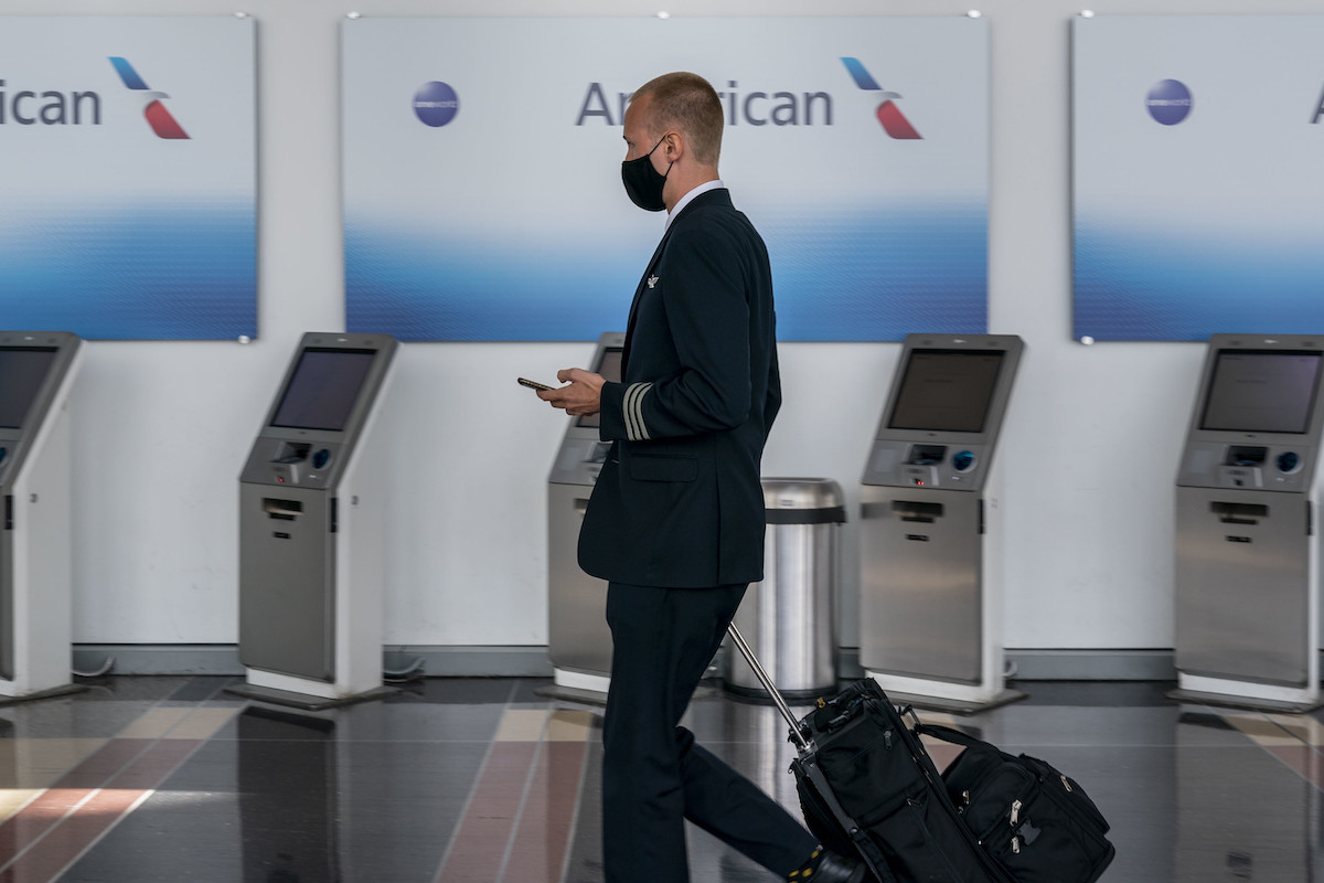 A pilot walks by an American Airlines counter