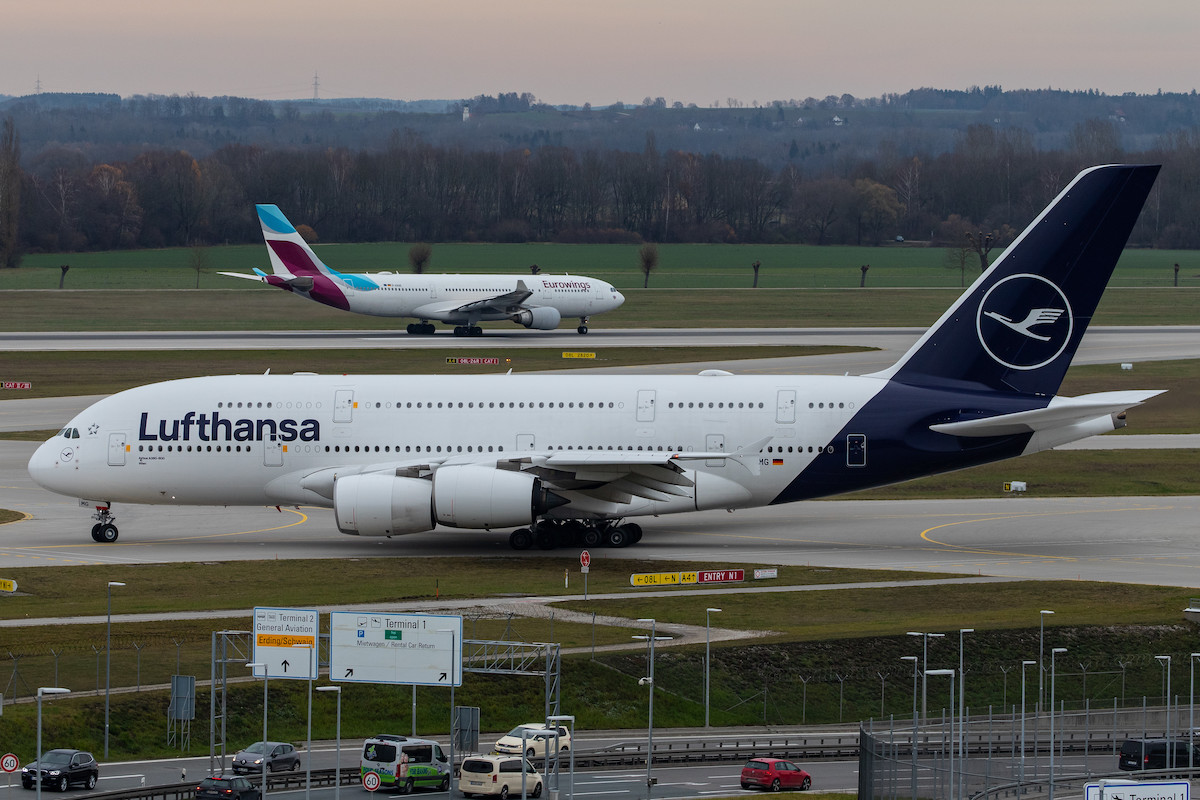 A Lufthansa A380 and Eurowings jet taxi at the Munich airport.