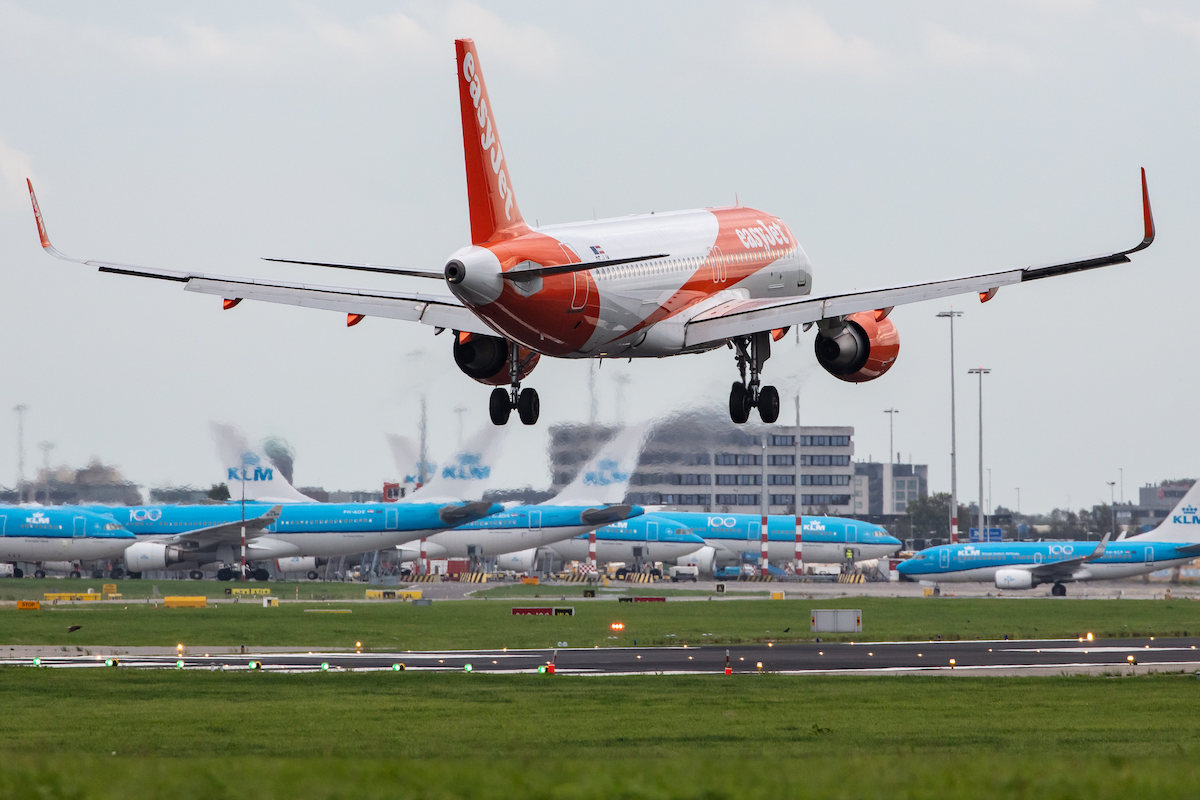 An EasyJet plane lands at Amsterdam Schiphol with KLM planes in the background