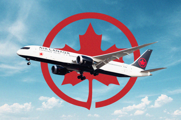 An Air Canada plane flying in front of the airline's logo.